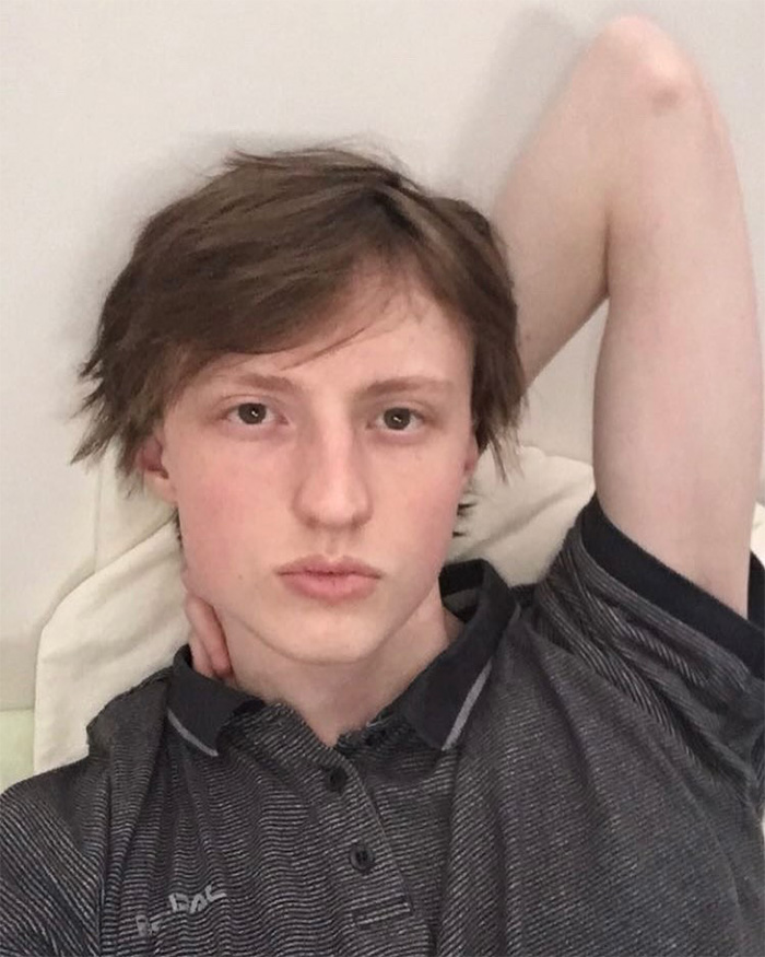 Close-up selfie of young looksmaxxer with hand behind head