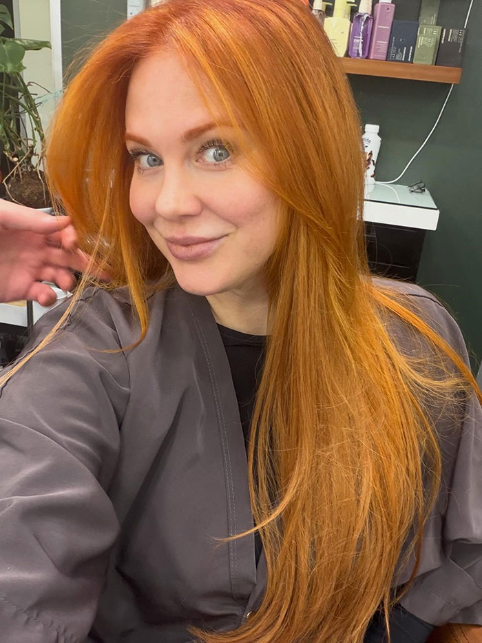 Former Disney star with long red hair smiling in salon Former Disney star with long red hair smiling in salon