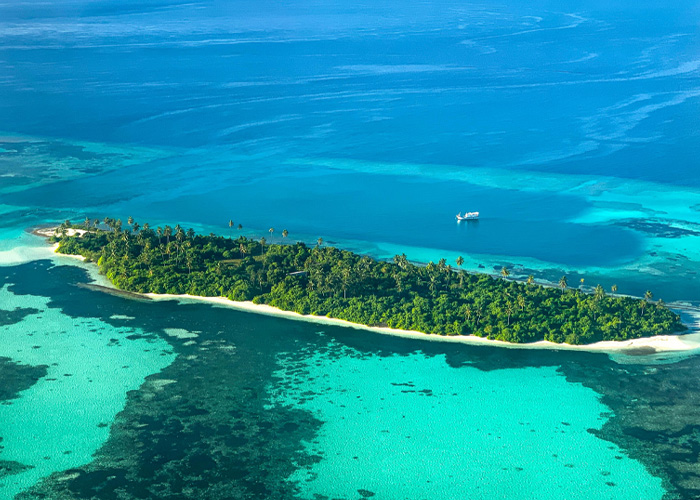 Vista aérea da ilha tropical com águas claras e recifes de corais no mistério do mergulho nas Maldivas