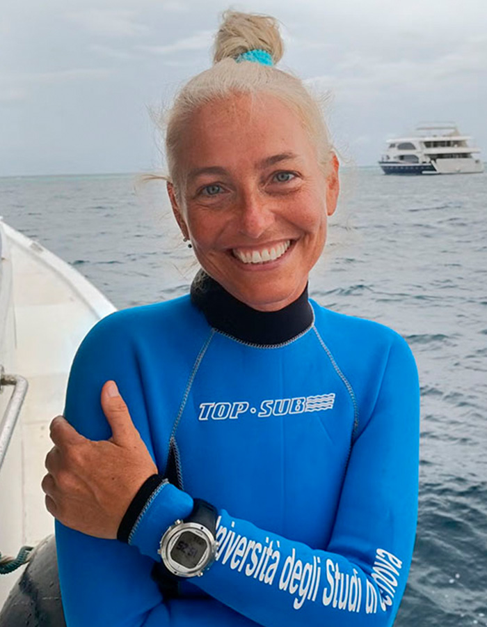 Mergulhador livre sorridente em roupa de mergulho azul perto do oceano no mistério do mergulho nas Maldivas