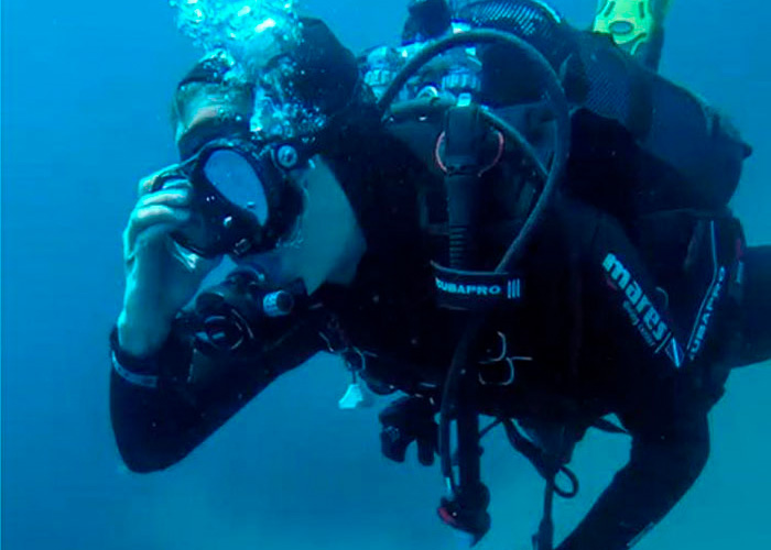 Mergulhador usando equipamento completo debaixo d’água no mistério do mergulho em cavernas nas Maldivas