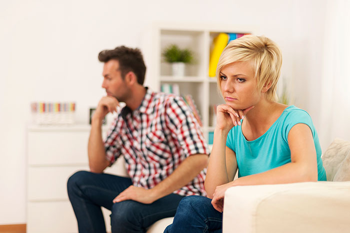 A man and woman sit apart, looking away from each other, deep in thought after her affair. He plans to break her heart. A man and woman sit apart, looking away from each other, deep in thought after her affair. He plans to break her heart.