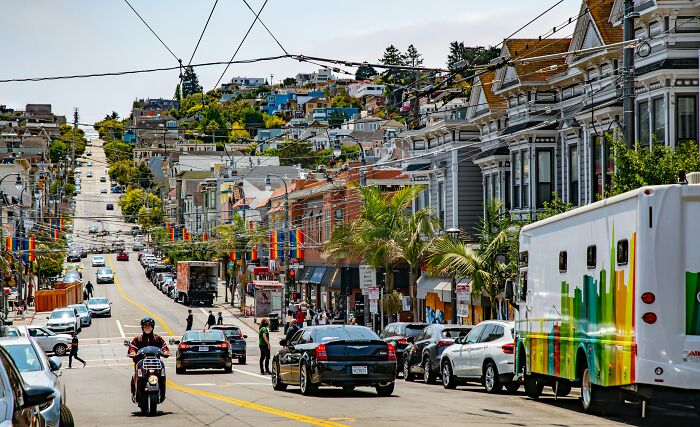 San Francisco street with colorful buildings and vehicles on a sunny day featuring geography facts