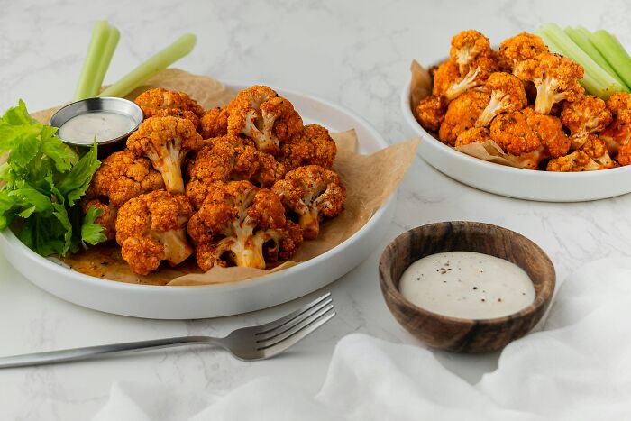 Spicy roasted cauliflower florets with celery sticks and ranch dressing. A tasty habit that might save you money.