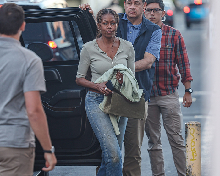 Michelle Obama walking with serious expression and casual outfit