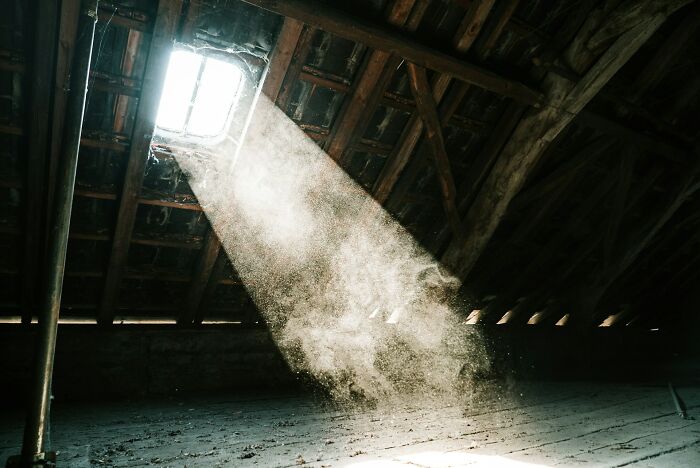 Dust particles illuminated by sunlight streaming through an attic window