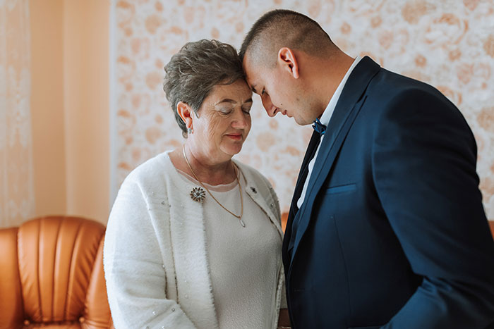 A mother and son touch foreheads in a house, sharing a loving moment for Valentine's Day.