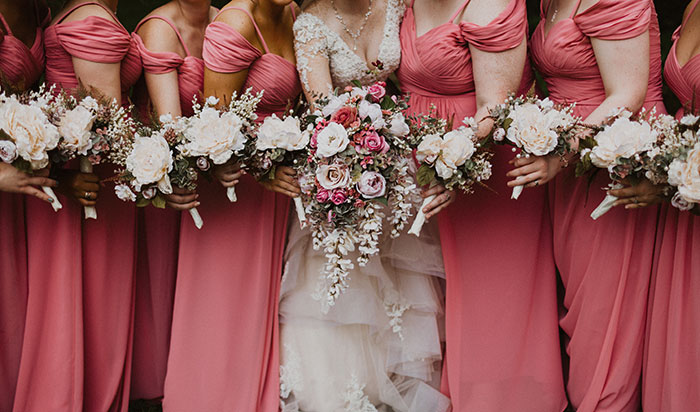 Bride and bridesmaids in pink dresses holding bouquets at a pink and black themed wedding Bride and bridesmaids in pink dresses holding bouquets at a pink and black themed wedding
