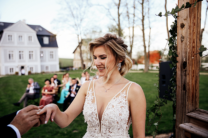 Bride smiling during wedding ceremony honoring her late dad outdoors