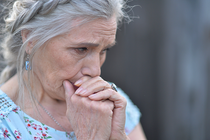 Emotional older woman reflecting with grief during wedding