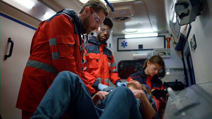 EMT crew attends to a patient in an ambulance, reflecting moments when doctors wonder how people are even alive.