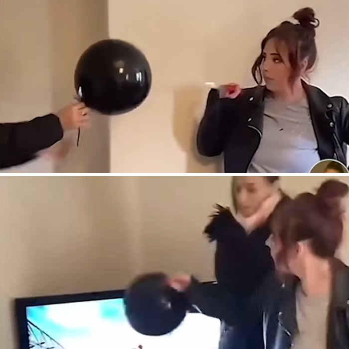 Woman holding black balloon at indoor gender reveal party footage
