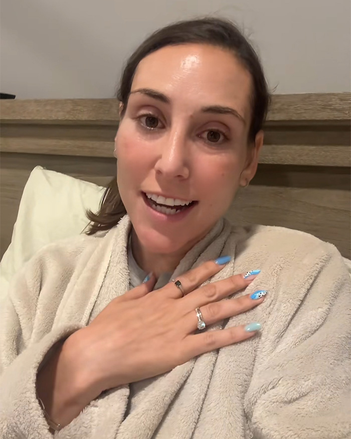 A Momfluencer, possibly discussing her emetophobia and sick toddler incident, wears a robe while speaking to the camera.