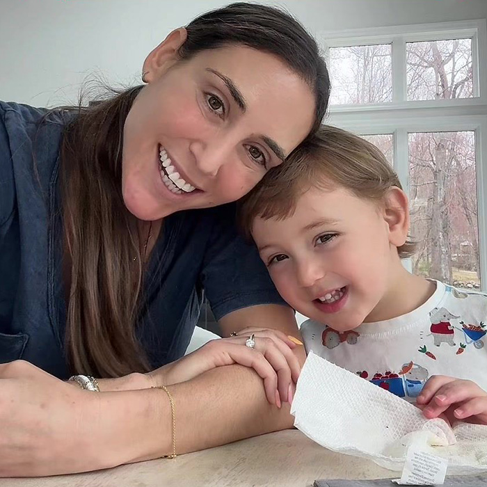 A Momfluencer smiling with her toddler. She has emetophobia and made her sick toddler sleep in the driveway.
