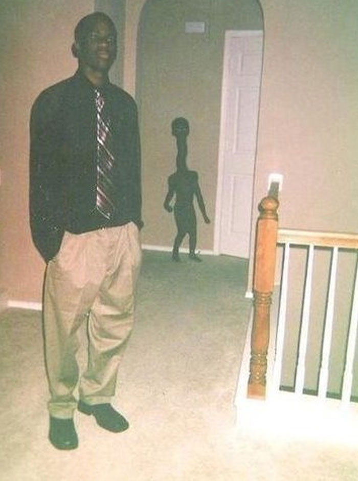 Paranormal figure behind man in hallway captured in photo