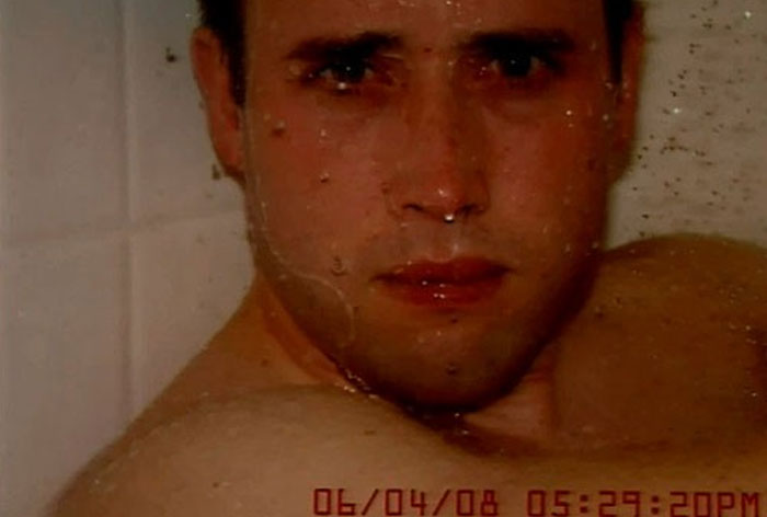 Creepy close-up portrait of man with eerie stare in shower