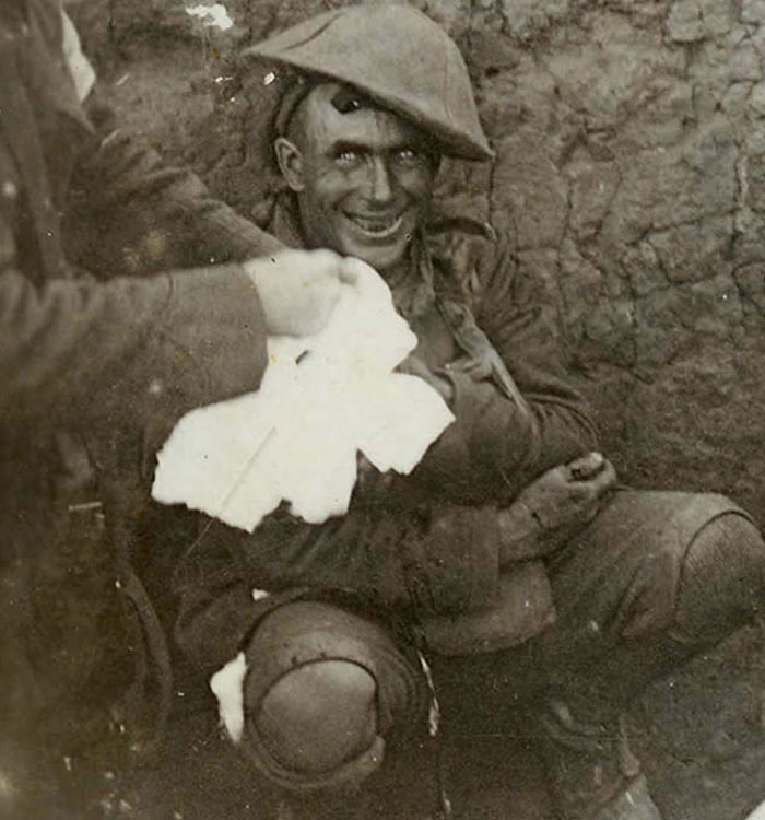Disturbing vintage war photo of soldier with unsettling smile in trench