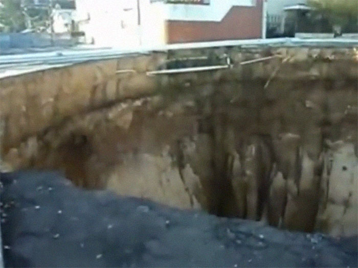 Massive sinkhole in urban area illustrating highly disturbing scene