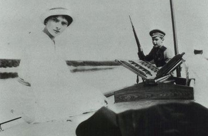 Old black and white photo of people on boat with one holding rifle