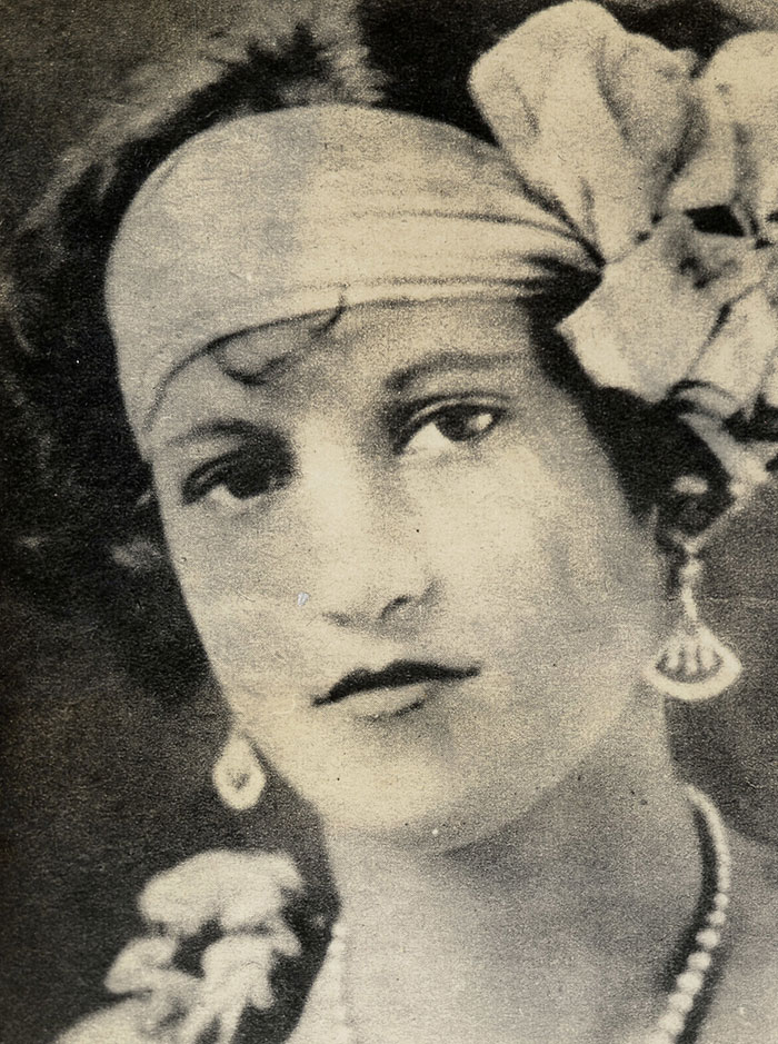 Vintage black and white portrait of a woman with headband and flower