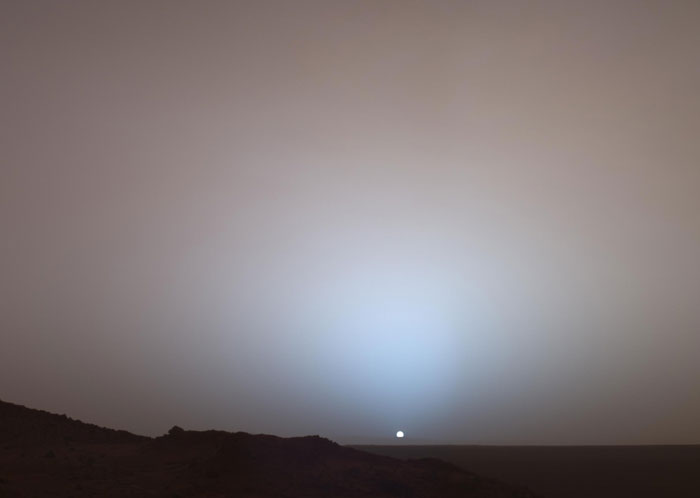Powerful photo of Martian sunset with sun near horizon and glowing sky