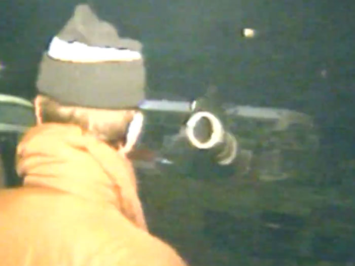 Man looking through a telescope in a dark setting capturing powerful moments