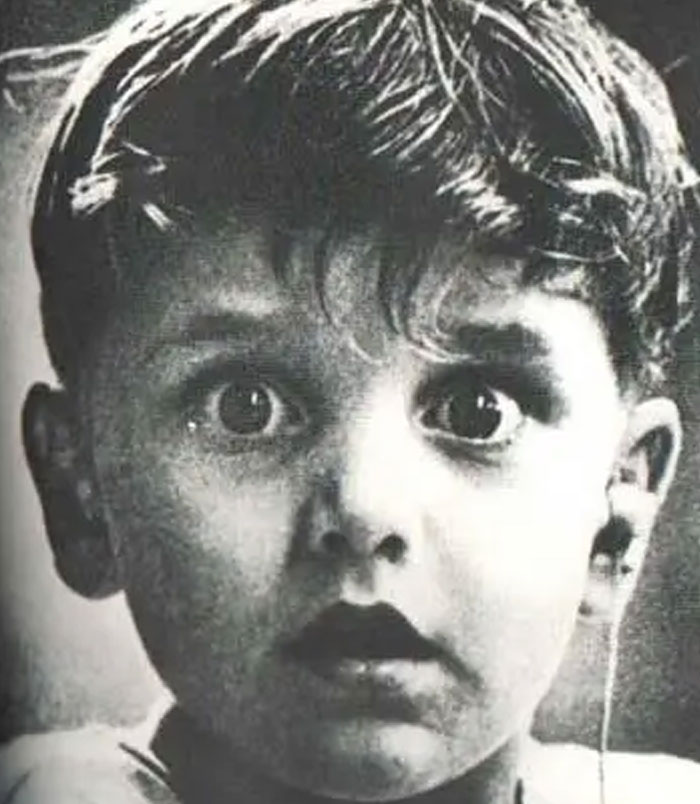 Close-up black and white photo of a scared child with wide eyes