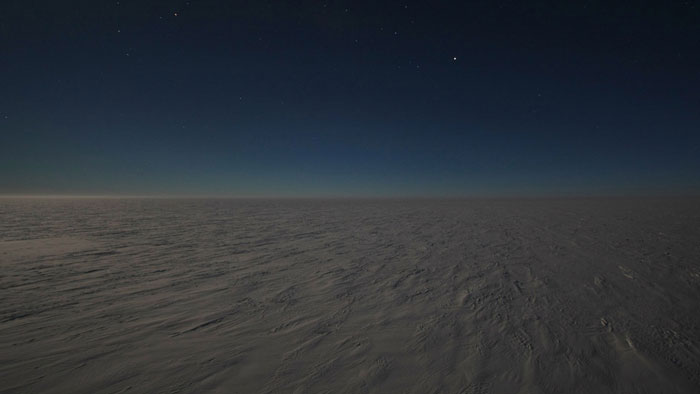 Powerful photo of vast frozen Antarctic landscape under a starry night sky