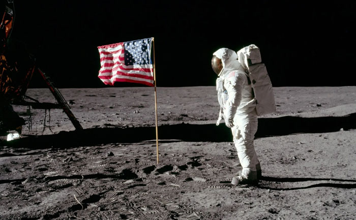 Astronaut on lunar surface with American flag in powerful photos