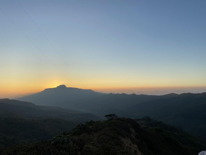 Sunset over mountain range with silhouette of hills and fading light