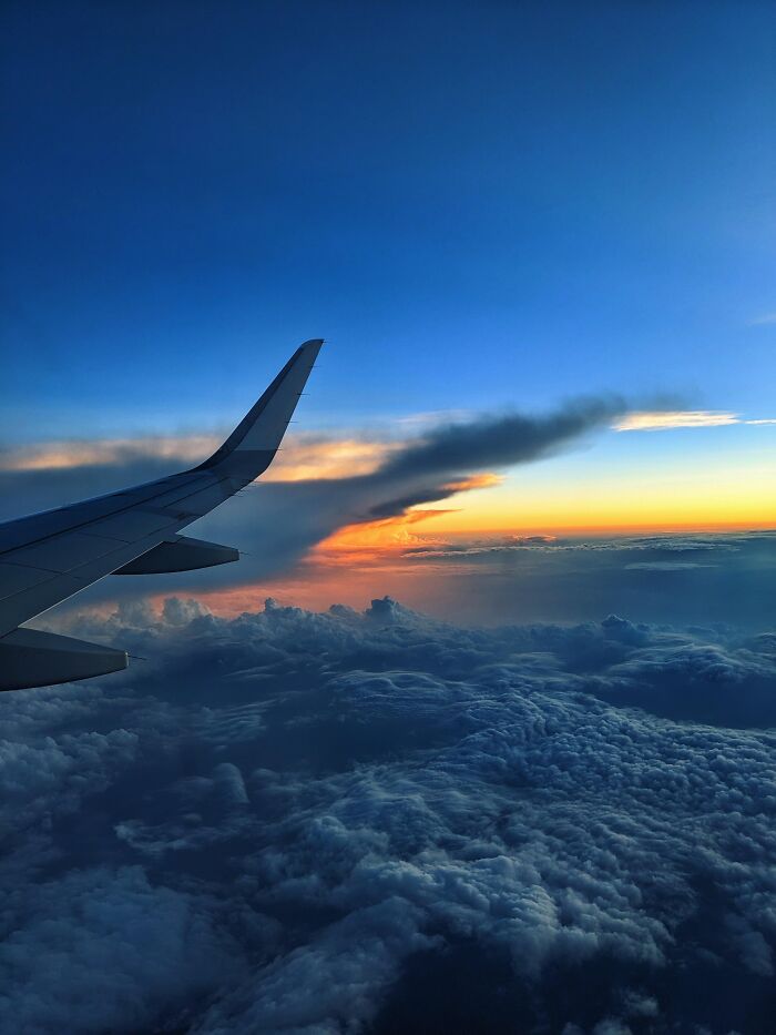 View of airplane wing during sunset over clouds in incredible photos collection