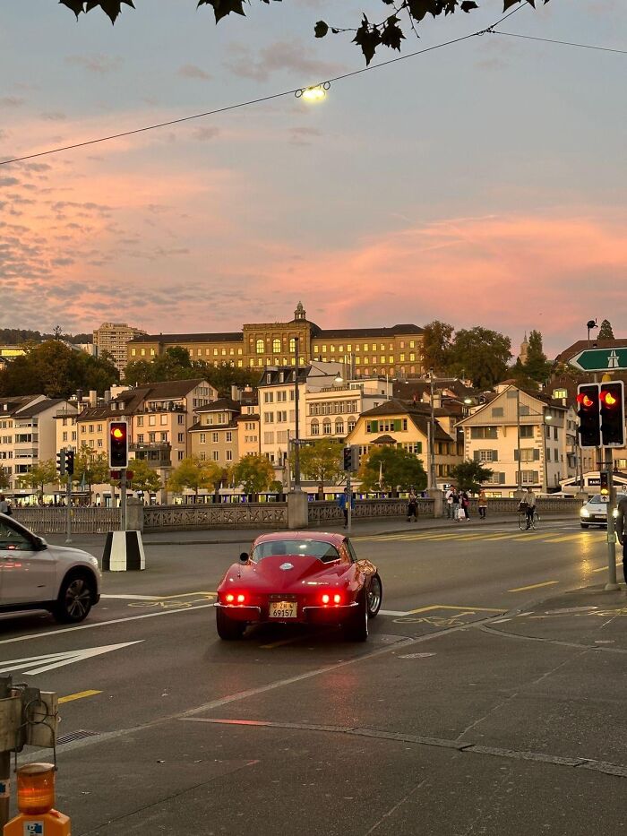 Incredible random camera clicks showing vintage red car driving in city street at sunset