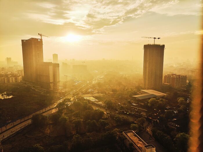 Golden hour cityscape photo with tall buildings and sun in incredible random camera clicks