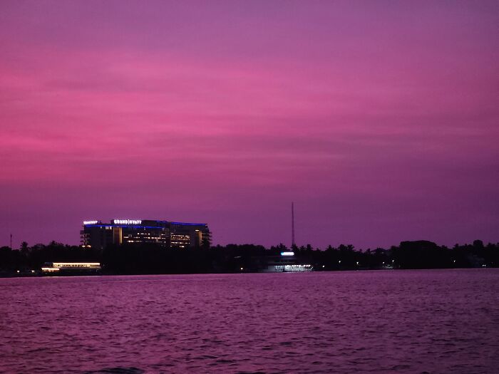 Purple sunset over river with buildings and trees in distance random camera clicks