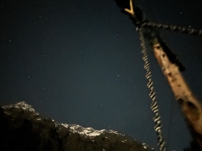 Starry night sky with mountain silhouette and wooden pole random camera clicks