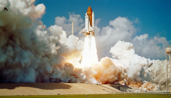 Space shuttle launching with fire and smoke during lift-off