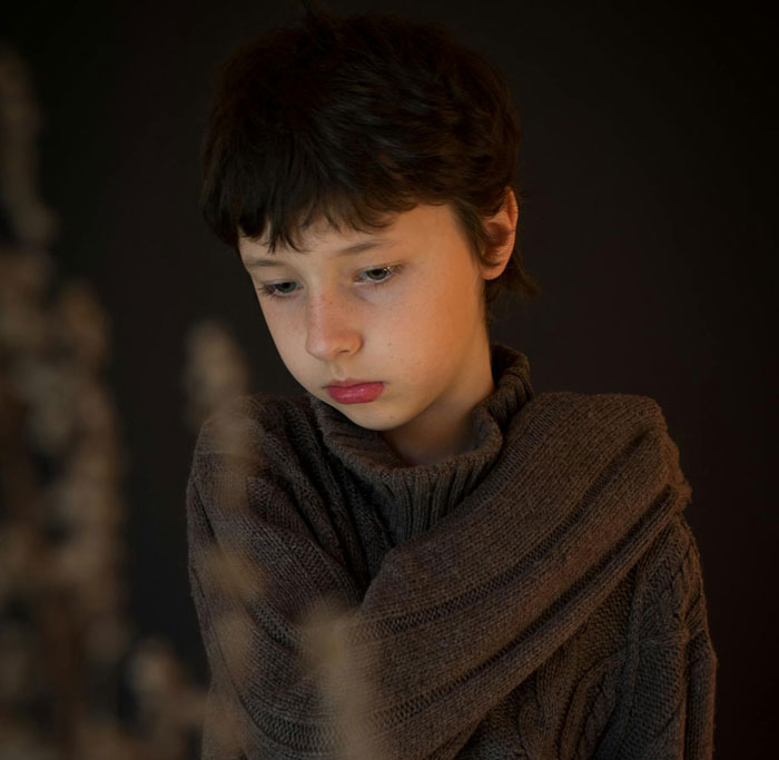Sad 10-year-old boy feeling hurt from toxic parents treatment