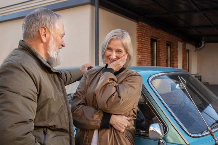 A funny neighbor is running and stalking by observing an elderly couple near a car. A funny neighbor is running and stalking by observing an elderly couple near a car.