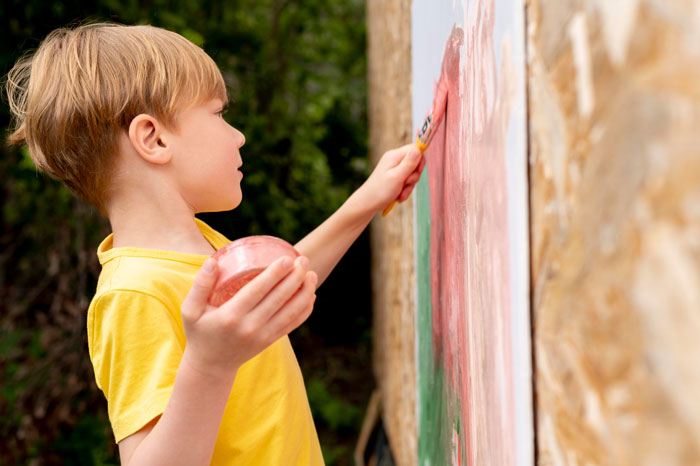 Child painting a wooden fence causing neighbor dispute