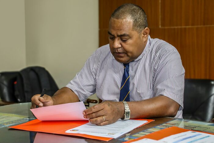 Man reviewing papers at office desk representing careful decision making and quitting for peace