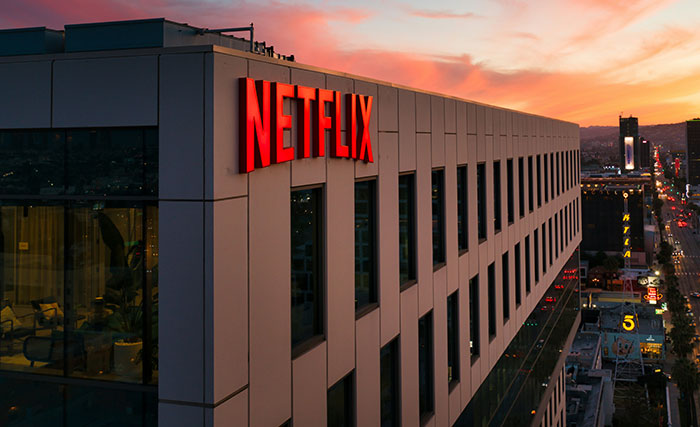 Netflix headquarters building at sunset with company sign Netflix headquarters building at sunset with company sign