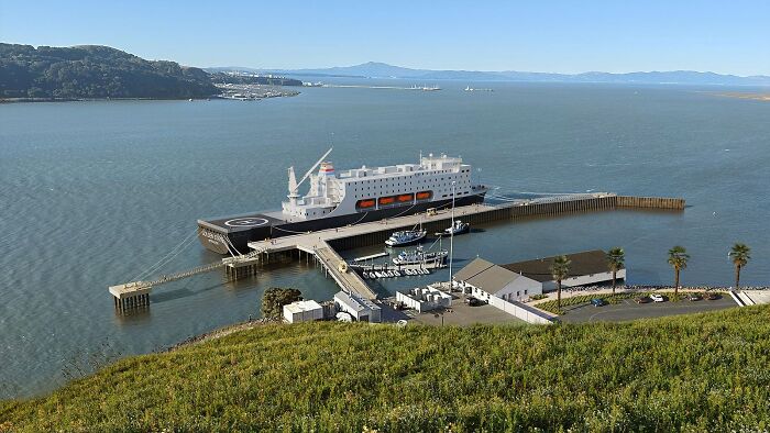 Large ship docked at a coastal port with a marina