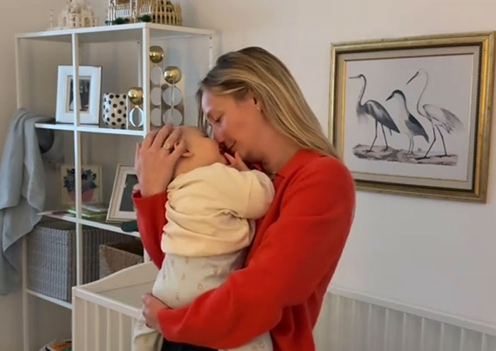 Mother embracing baby indoors showing benefits of Germany maternity leave Mother embracing baby indoors showing benefits of Germany maternity leave