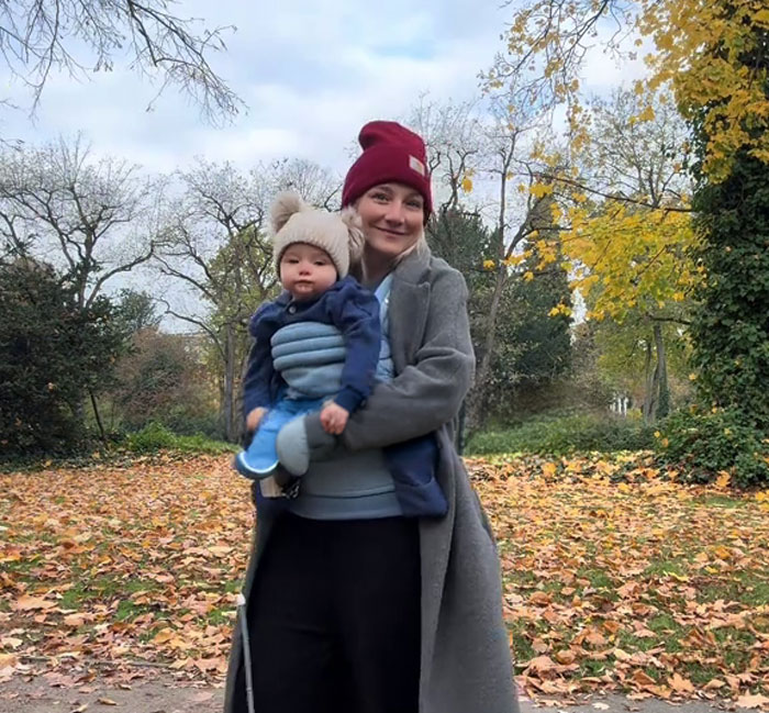 Woman holding baby in autumn park highlighting Germany full paid maternity leave Woman holding baby in autumn park highlighting Germany full paid maternity leave