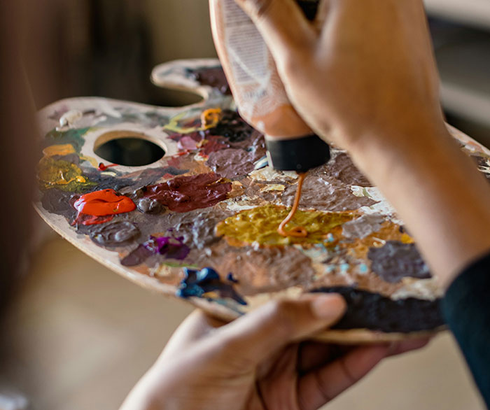 Close-up of hands squeezing paint onto an artist's palette, reflecting the arts lovers and biological age study. Close-up of hands squeezing paint onto an artist's palette, reflecting the arts lovers and biological age study.