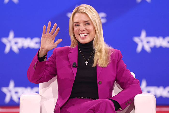 Former Attorney General Pam Bondi smiling and waving at political conference event Former Attorney General Pam Bondi smiling and waving at political conference event
