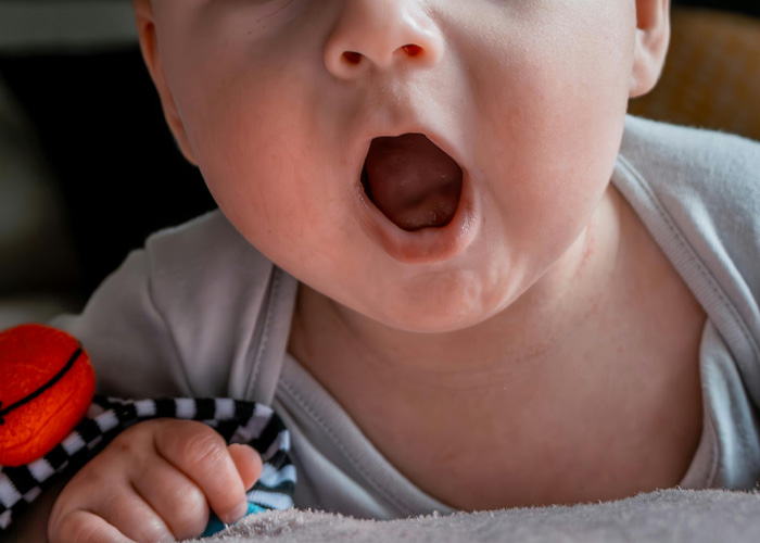 Close-up of baby with open mouth related to looksmaxxing
