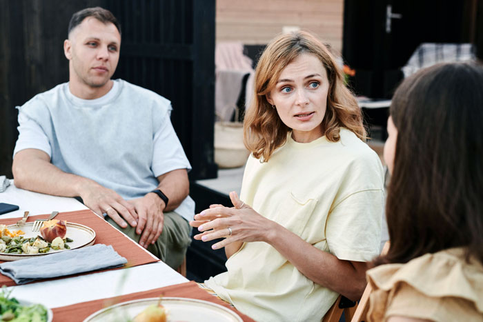 A woman with an inheritance and a man sitting at a table with plates of food. She discusses a house deposit.