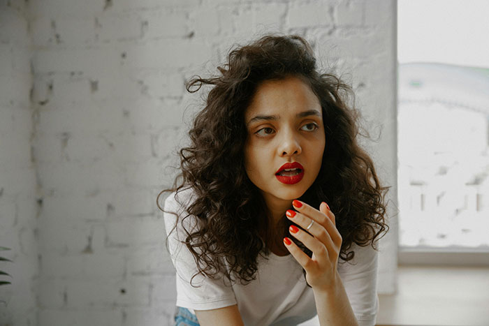 Woman with curly hair looking worried, symbolizing cheating story emotions