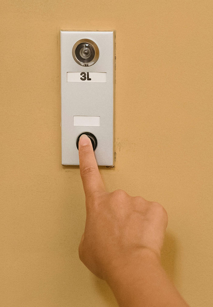 Finger pressing doorbell with number 3L representing confrontation in cheating stories